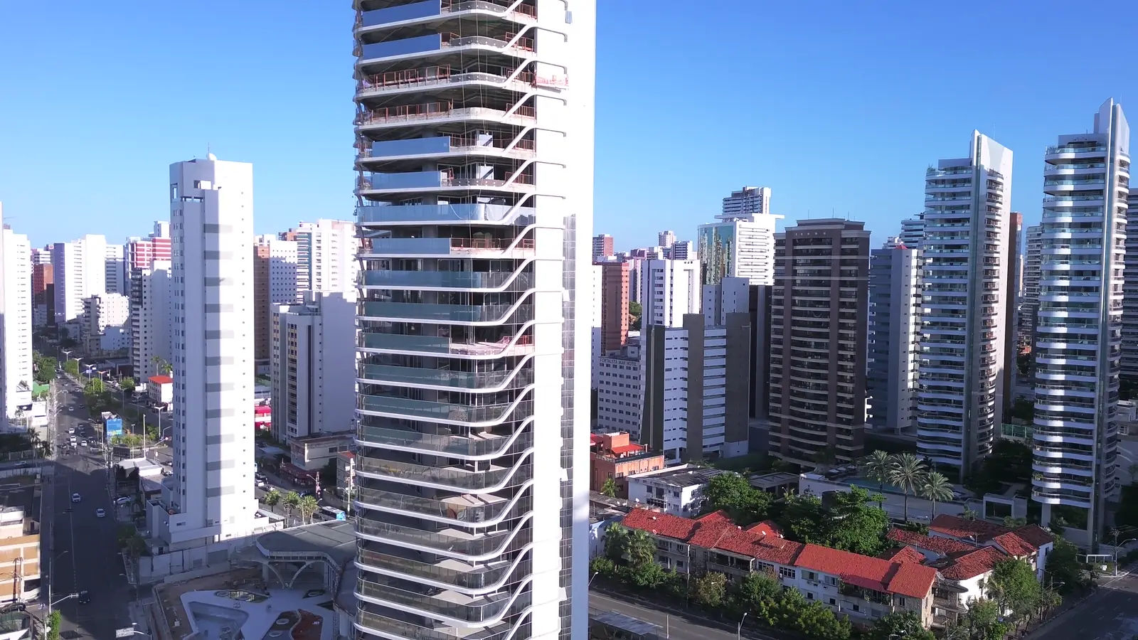 Aerial orbit around a residential tower over the city skyline